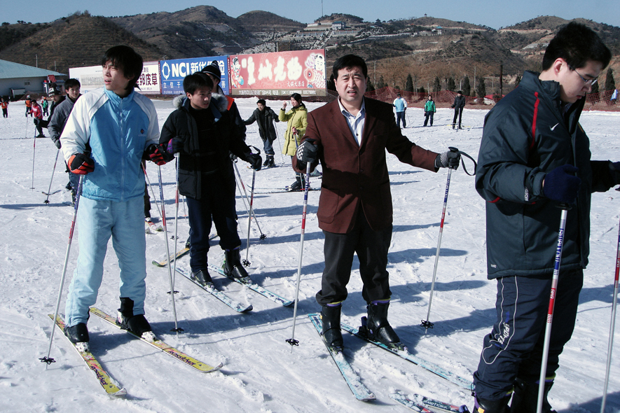 A Chinese man wearing a suit enjoys a day out skiing at Linhai Ski resort in Dalian.