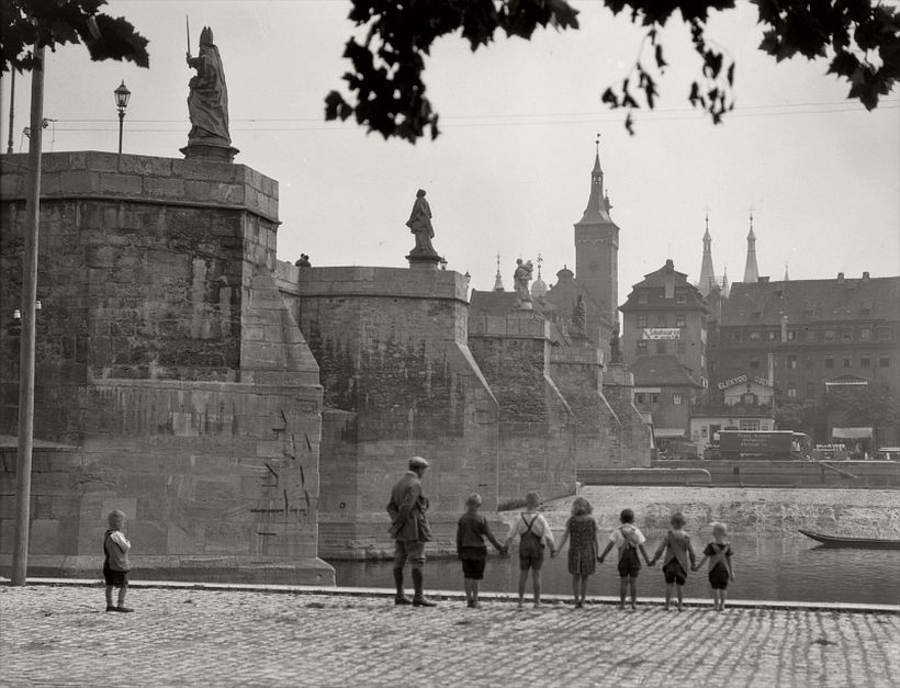 Bridge with statues seen from below, group of children holding hands, Würzburg, 1925
